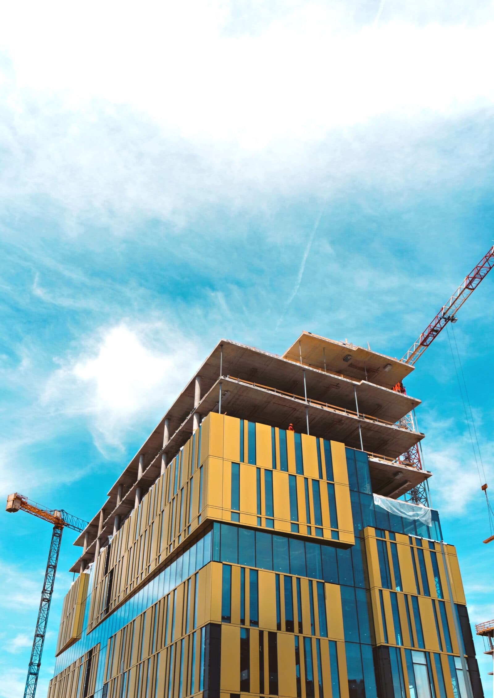 A tall and complex structure under construction, with several floors and a large roof.